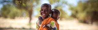 Un jeune garçon au Turkana, au Kenya, porte son frère ou sa sœur.