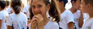 Une fille mangeant dans la cour de l'école.